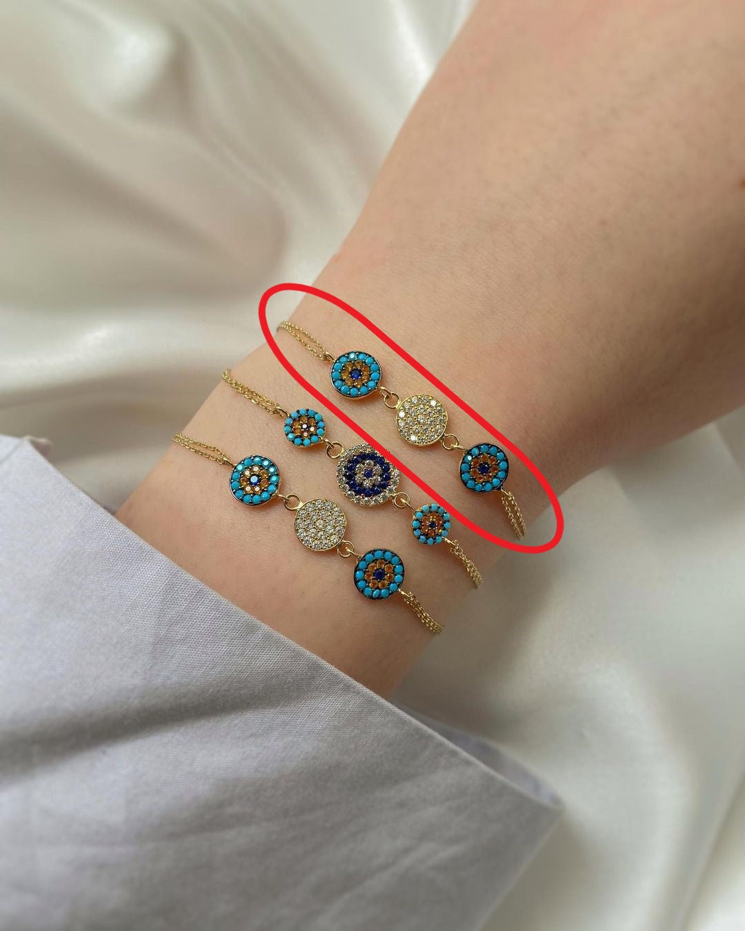 Goldarmschmuck mit drei Anhängern in blau